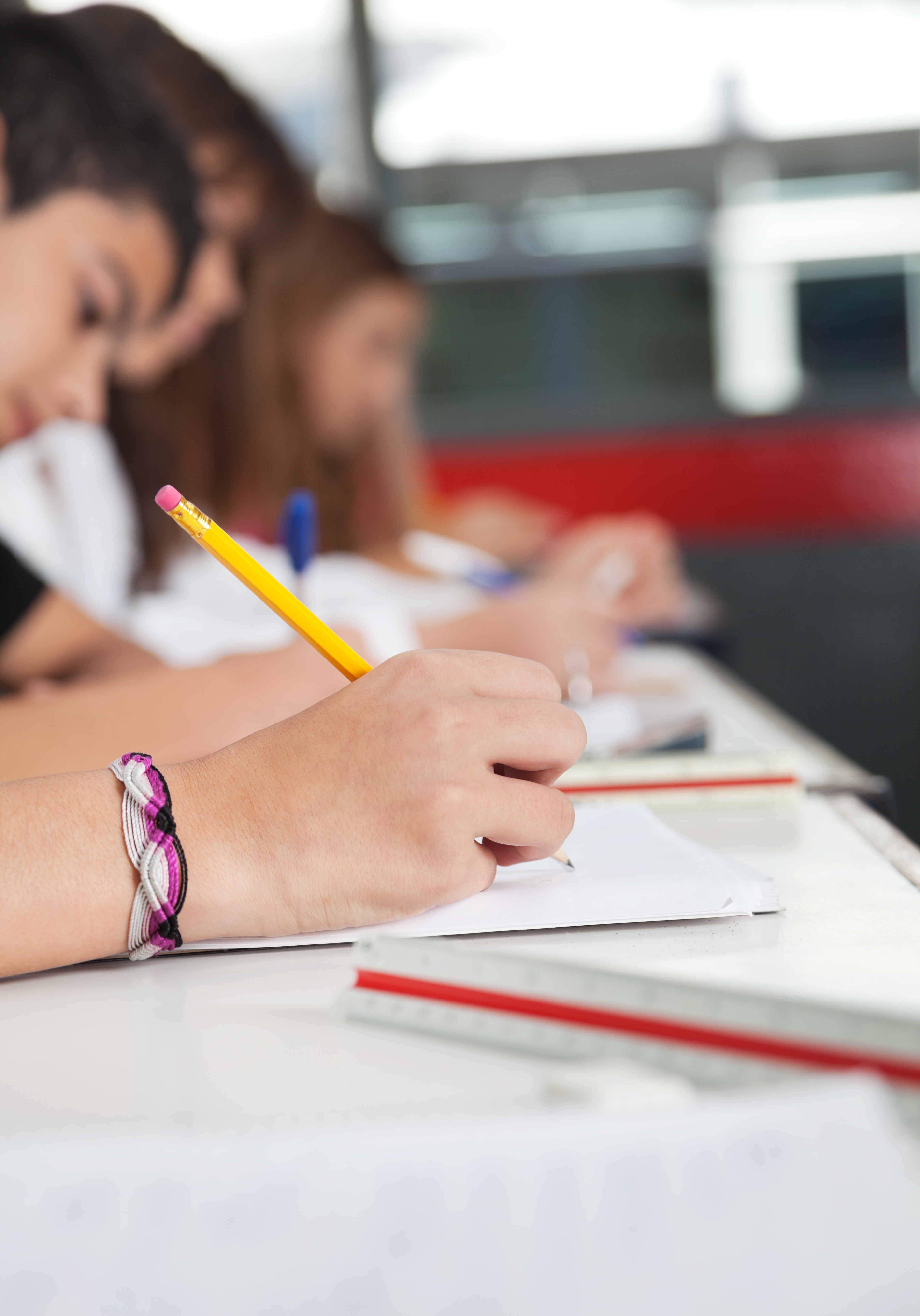 La imagen muestra estudiantes escribiendo textos