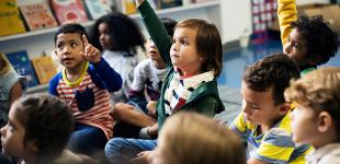 La imagen muestra un grupo de niños y niñas participando en una actividad