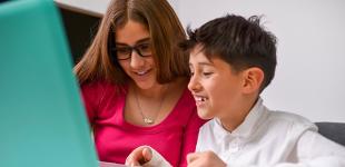 Estudiante junto a su profesora utilizando herramientas TIC