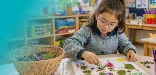 Niña realizando manualidades en sala de clases.