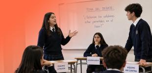 Grupo de estudiantes de educación media debatiendo en sala de clases.