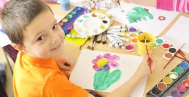La imagen muestra a un niño realizando un dibujo con tempera