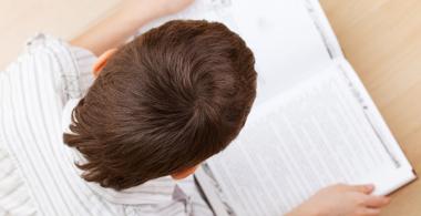 La imagen muestra a niño leyendo un texto