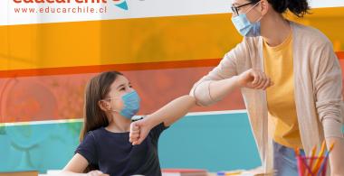 Estudiante y docente con mascarilla se saludan con el codo.