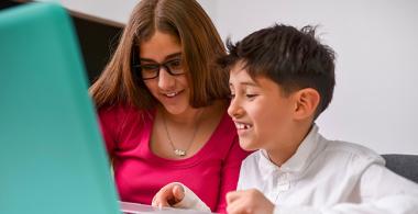 Estudiante junto a su profesora utilizando herramientas TIC